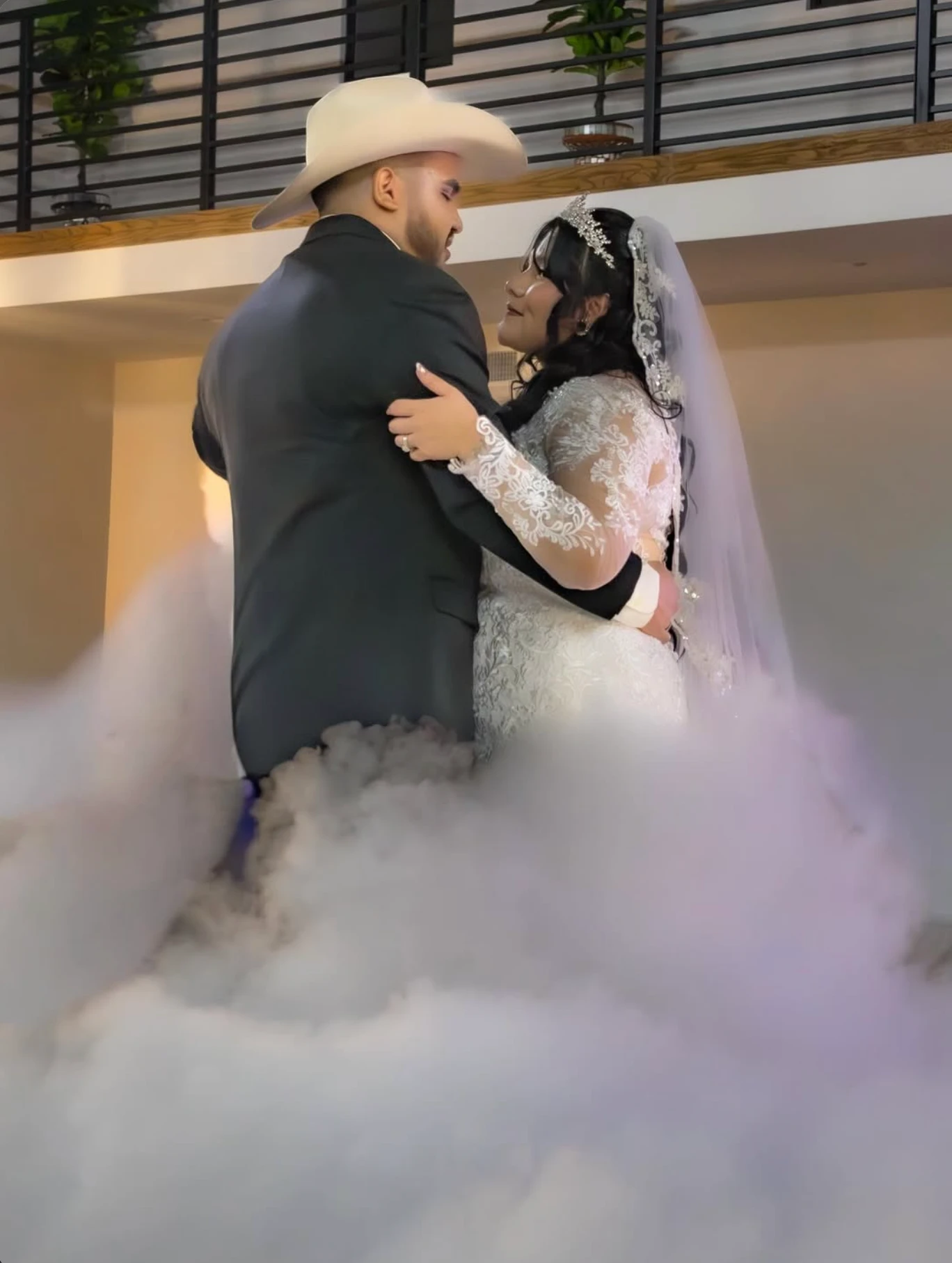 Los novios en su primer baile, él con sombrero vaquero, rodeados de humo bajo